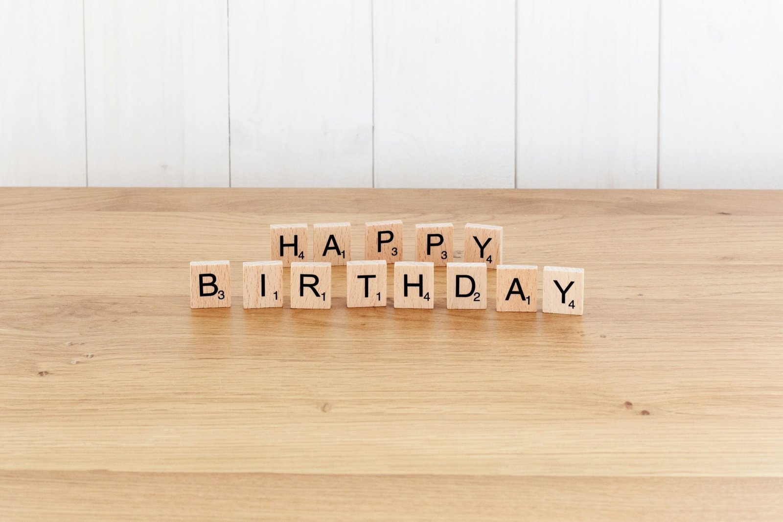 a wooden block spelling happy birthday on a table